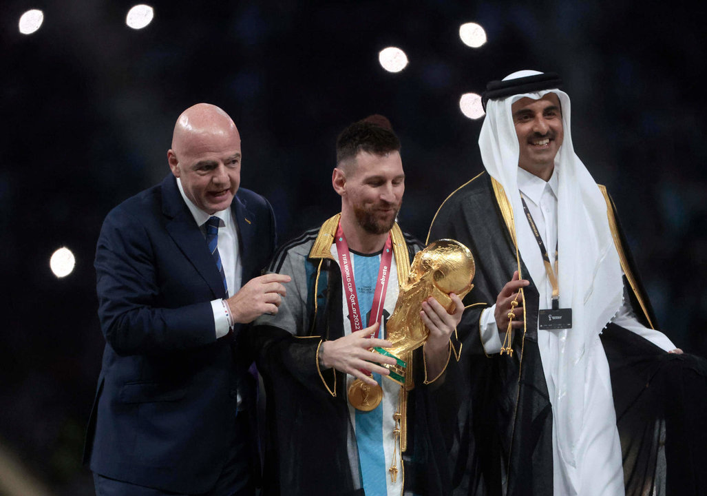 Lionel Messi (c) de Argentina posa con el trofeo de la Copa del Mundo junto a el presidente de la FIFA Giovanni Vincenzo (i) y el Emir del Estado de Catar, en la final del Mundial de Fútbol Qatar 2022 entre Argentina y Francia en el estadio de Lusail (Catar). EFE/ Juan Ignacio Roncoroni